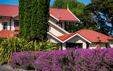 image shows a garden in front of a historical homestead