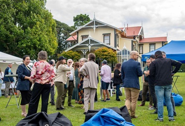 image shows an outdoor reception outside a historical homestead