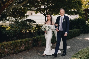 image shows a man walking with a bride 